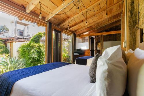 a bedroom with a bed and a large window at Sereno Art Hotel in San Cristóbal de Las Casas