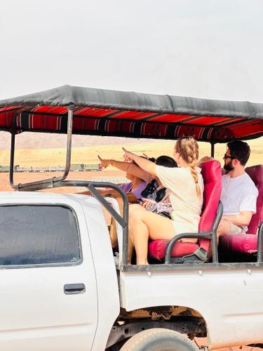 a group of people sitting in the back of a truck at Rum Kingdom Camp in Wadi Rum