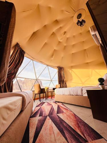 a room with two beds and a large window at Rum Kingdom Camp in Wadi Rum