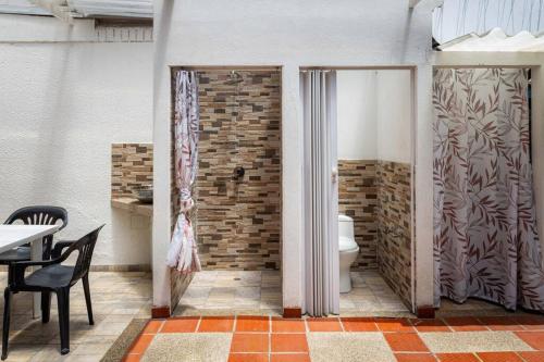 a bathroom with a toilet and a brick wall at Enorme Casa Campestre en Bogotá in Bogotá