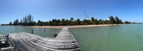 un muelle de madera en el agua junto a una isla en Sabal Beach, en Punta Gorda