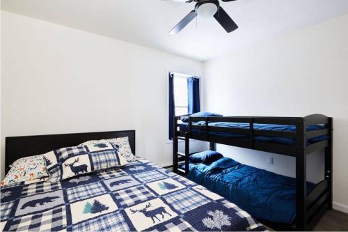 Pocono Lake的住宿－Casa di Montagna/5BR/3Bath/NearResorts/PetsAllowed，一间卧室设有两张双层床和吊扇