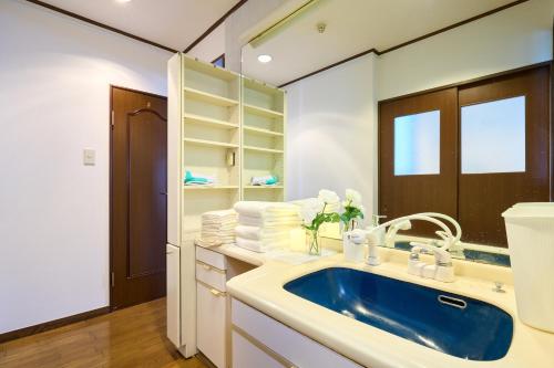 a bathroom with a blue sink and white cabinets at Near Shibuya! 150 sq m Private floor & Japanese garden in Tamagawa