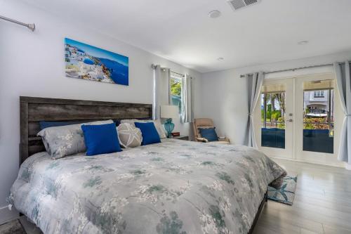 a bedroom with a large bed with blue pillows at Secluded Family Serenity on Canal with 2 Bikes and Beach Chairs in Naples