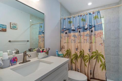 uma casa de banho com um lavatório e uma cortina de chuveiro em Secluded Family Serenity on Canal with 2 Bikes and Beach Chairs em Naples