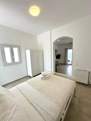 ein weißes Schlafzimmer mit einem großen Bett darin in der Unterkunft The Dice in Pachaina