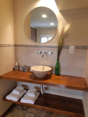 W łazience znajduje się umywalka, lustro i ręczniki. w obiekcie Duplex Mi Lar w mieście Termas de Río Hondo