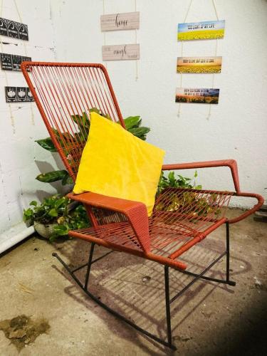 a orange chair with a yellow pillow on it at Hostel Casa Mar in Liberia