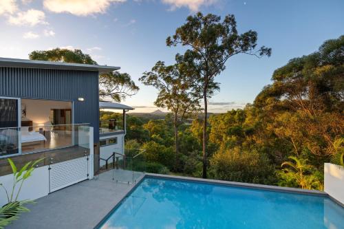 a house with a swimming pool next to a house at Hinterland Dreamers Poolside Retreat in Yandina Creek