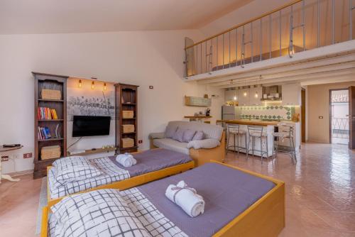 sala de estar con 2 camas y cocina en Casa La Rocca, en Olbia