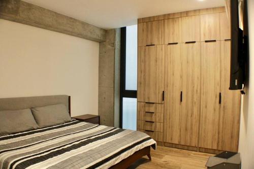 Un dormitorio con una cama y un armario de madera. en Brujas Tower- Hermoso departamento a pie de playa., en La Florida