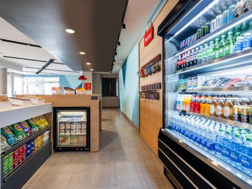 an aisle of a store with bottles of soda at avid hotel Oklahoma City - Quail Springs by IHG in Oklahoma City