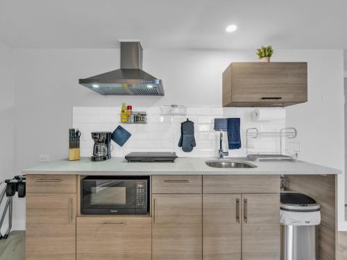 a kitchen with a sink and a microwave at Cliffside Suite #3 - Seacliff Beach Suites in Leamington