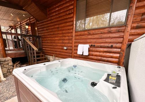 une baignoire jacuzzi dans une cabane en rondins dans l'établissement Pine Ridge Lodge, à Show Low