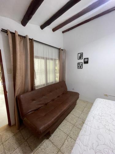 a couch sitting in a room with a window at Ancestral Casa de Campo in Roldanillo