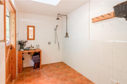 a bathroom with a shower and a wooden table at Mumfords in Akaroa