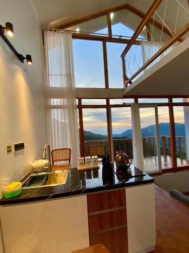 uma cozinha com uma bancada com uma grande janela em Tribuana villa dieng em Wonosobo