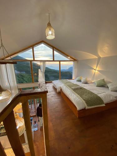 um quarto grande com uma cama e uma janela grande em Tribuana villa dieng em Wonosobo