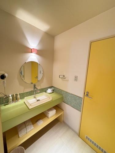 bagno con lavandino e specchio di Hotel JOYCE a Saijō-chō