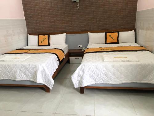 two beds sitting next to each other in a room at hotel Hương Thiên Phú in Dĩ An
