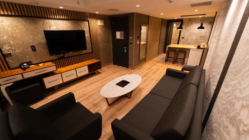 een woonkamer met een bank en een tv bij Mas Suites Nisantasi in Istanbul