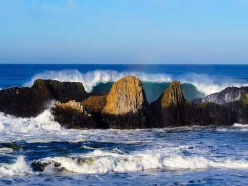 a wave crashing on the rocks in the ocean at Breakers - stay in a tiny home on the Oregon Coast in Waldport