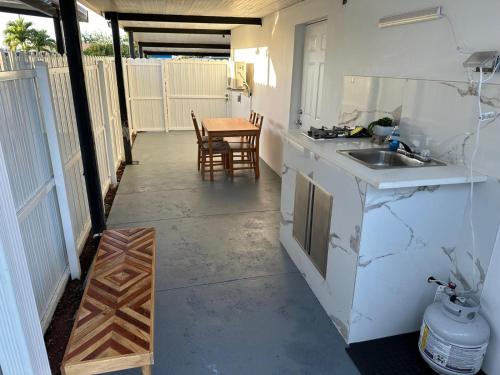 a kitchen with a sink and a table with chairs at Adrien Guest Studio in Miami Gardens