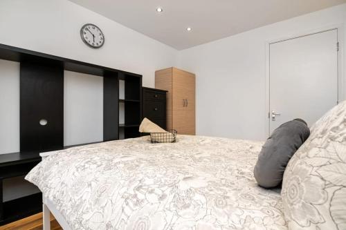 a bedroom with a bed with a clock on the wall at Modern House Just Refurbished in London