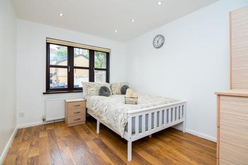 a white bedroom with a bed and a window at Modern House Just Refurbished in London