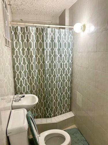 a bathroom with a shower and a toilet and a sink at Steps 2 Beach - 5 Bedroom 3 Bathroom Villa in Christ Church
