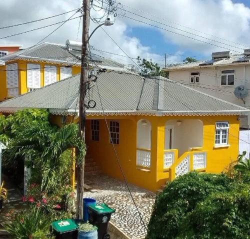 a yellow and white house with at Steps 2 Beach - 5 Bedroom 3 Bathroom Villa in Christ Church