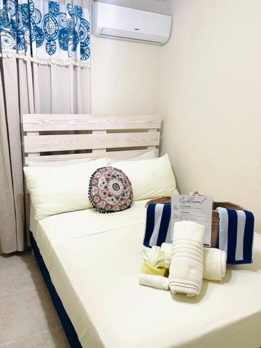 a white bed with pillows and towels on it at Steps 2 Beach - 5 Bedroom 3 Bathroom Villa in Christ Church