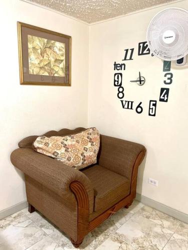 a couch in a room with a clock on the wall at Steps 2 Beach - 5 Bedroom 3 Bathroom Villa in Christ Church