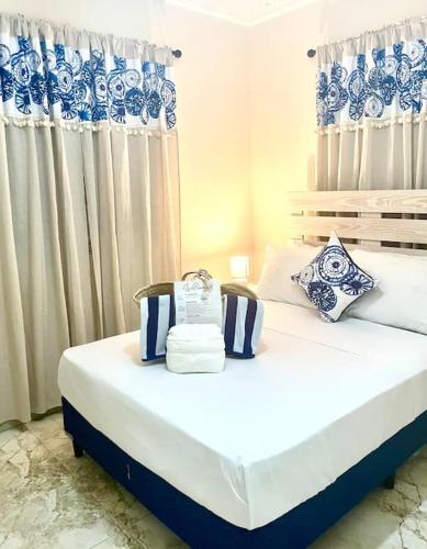 two beds in a room with blue and white curtains at Steps 2 Beach - 5 Bedroom 3 Bathroom Villa in Christ Church