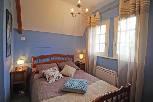 um quarto azul com uma cama com duas almofadas em Les deux chenes em Saint-Denis-des-Murs