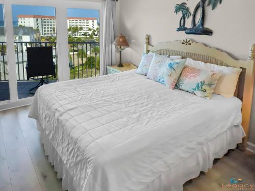 1 dormitorio con 1 cama blanca grande con almohadas en SC 601b - Bchfront -Free Seasonal Beach Service! en Fort Walton Beach