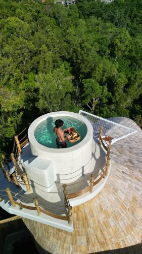 a person in a circular pool on a house at Camanta Penida - Adult Only in Nusa Penida