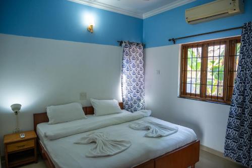 1 dormitorio con 1 cama con 2 toallas en Franria Villa Guest House en Calangute