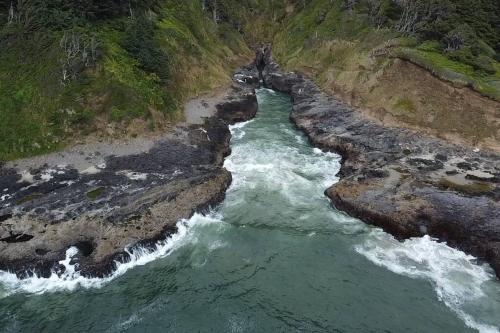 an aerial view of a river between two cliffs at Shorepine - Tiny Tranquility on the Oregon Coast! in Waldport