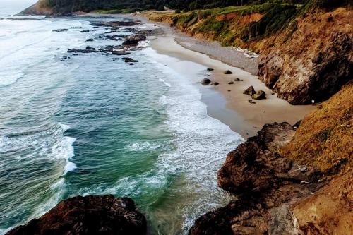 an aerial view of a beach with rocks and the ocean at Shorepine - Tiny Tranquility on the Oregon Coast! in Waldport