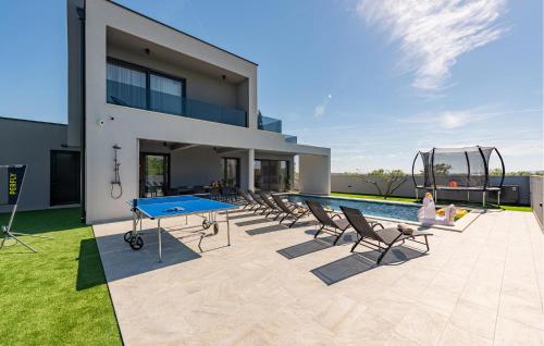 a house with a ping pong table and chairs at Gorgeous Home In Zadar in Zadar