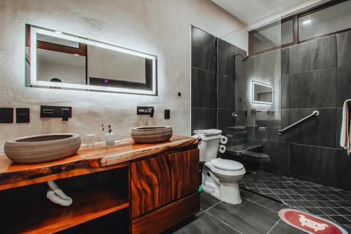 uma casa de banho com um lavatório e um WC em New La Manzanilla Paradise Vibrant Pool Home em La Manzanilla