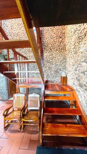 a room with two chairs and a wooden staircase at Los de Arriba Hotel Cabaña familiar con piscina en Calima in Darién