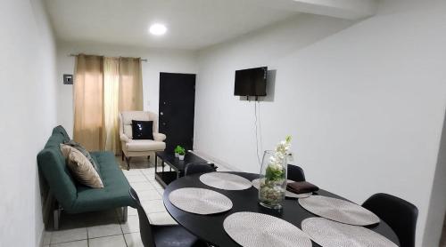 ein Wohnzimmer mit einem Tisch und einem grünen Sofa in der Unterkunft Departamento zona centro in Ciudad Madero