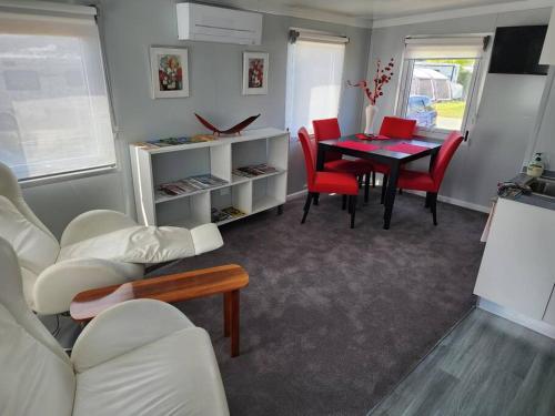 Our Casetta في ريتشموند: غرفة معيشة مع طاولة وكراسي حمراء