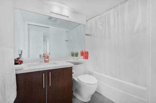 W łazience znajduje się toaleta, umywalka i lustro. w obiekcie Sleek 2BR Getaway Urban Pulse Waterfront Tranquility w mieście Vancouver