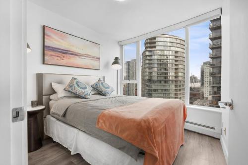 sypialnia z łóżkiem i dużym oknem w obiekcie Sleek 2BR Getaway Urban Pulse Waterfront Tranquility w mieście Vancouver