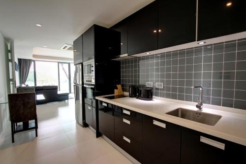 una cucina con armadi neri e lavandino di Lets Phuket Twin Sands Resort & Spa a Patong Beach