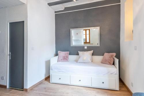 une chambre avec un lit blanc avec des oreillers roses dans l'établissement La Tour Médiévale au centre ville, à Annecy