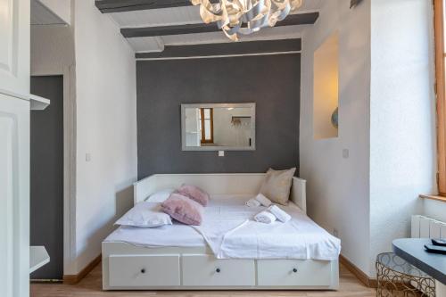 - un lit blanc dans une chambre avec un miroir dans l'établissement La Tour Médiévale au centre ville, à Annecy